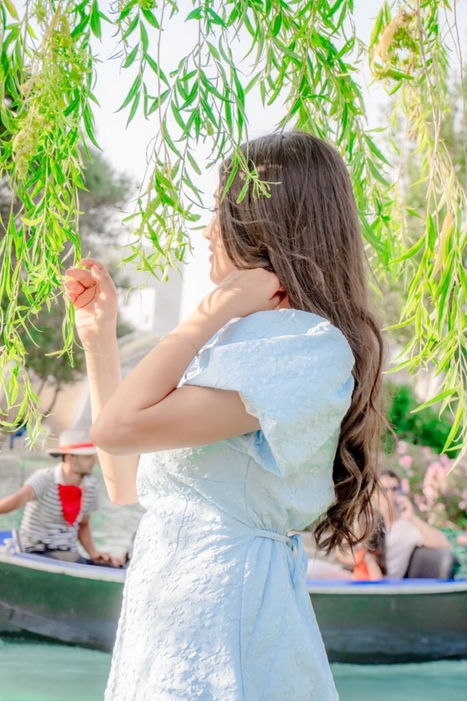 Woman in blue dress near weeping willow tree
